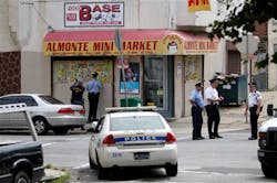 Investigators gather outside a corner store on N. 4th Street in the Feltonville section of Philadelphia on Aug. 13 after a police officer was shot.