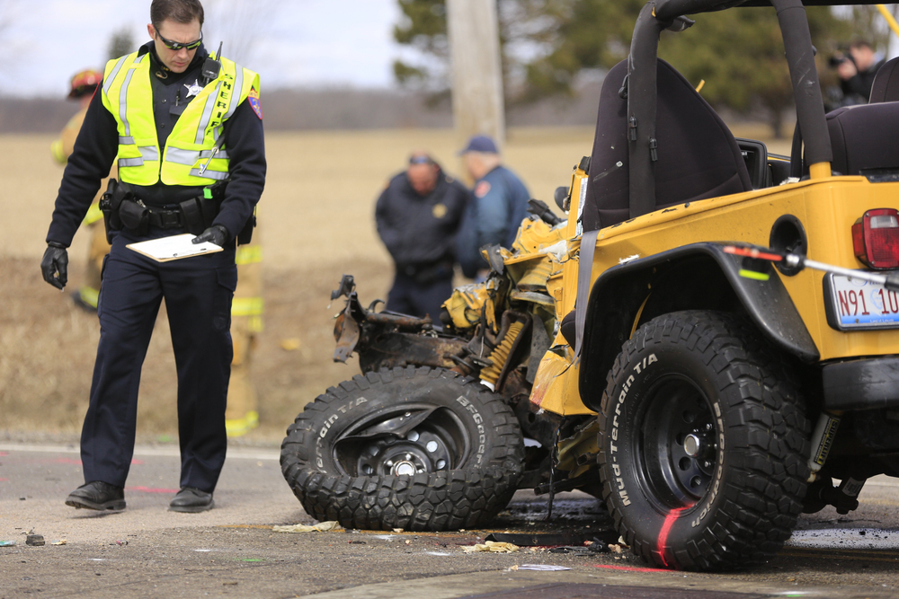 A Lake County Sheriff's Police investigator examines a vehicle involved on April 5 in an accident with a school bus near Zion, Ill.