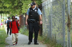 William Hawkins, a third-grader, is escorted by Chicago Police Officer Joe Wilson on Aug. 26. William Hawkins, a third-grader, is escorted by Chicago Police Officer Joe Wilson on Aug. 26.