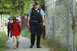 William Hawkins, a third-grader, is escorted by Chicago Police Officer Joe Wilson on Aug. 26.