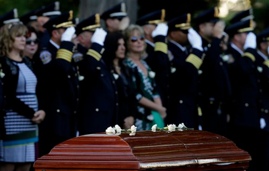 White carnations are placed on the casket of slain Indianapolis Officer Rod Bradway during a funeral service on Sept. 26.