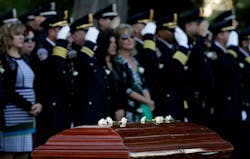 White carnations are placed on the casket of slain Indianapolis Officer Rod Bradway during a funeral service on Sept. 26. White carnations are placed on the casket of slain Indianapolis Officer Rod Bradway during a funeral service on Sept. 26.