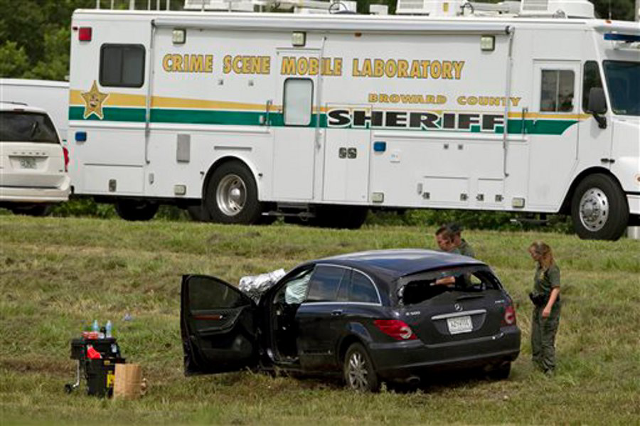Police investigate the vehicle of a suspect who police say is responsible for the deaths of three people after leading police on a high speed chase on Sept. 18 in Broward County, Fla.