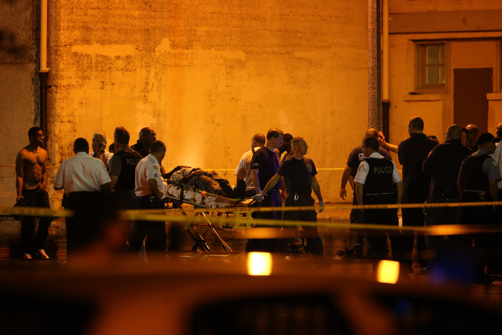 Chicago police and emergency medical personnel work at the scene of a multiple shooting at 50th and Wood Streets in Chicago on Sept. 19.