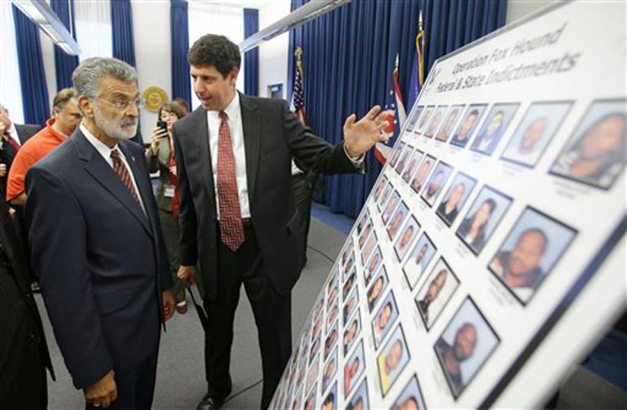 United States attorney for the Northern District Steven M. Dettelbach, right, and Cleveland Mayor Frank Jackson, left, look over the photographs of people indicted for heroin on Sept. 18 Cleveland.
