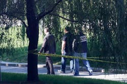 Crime scene investigators walk along a path in New York&apos;s Riverside Park South where a man earlier went on a rampage stabbing five people, including a toddler on Oct. 1.