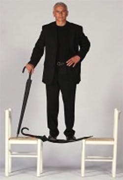 Unbreakable Umbrella inventor Thomas Kurz stands on one of his inventions suspended between two chairs. The umbrella worked perfectly afterwards.