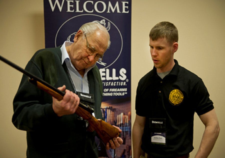 : Legendary custom gunmaker Jerry Fisher examines a student&apos;s work at GCCF 2013.