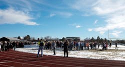 Sheriffs deputies stand guard over students after they were evacuated to the track and football field at Arapahoe High School in Centennial, Colo. on Dec. 13.