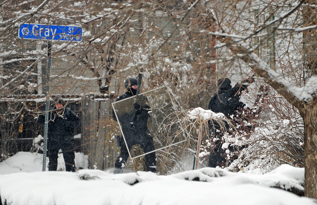 Police rush into a home during a hostage situation on Feb. 4 in Arvada, Colo.