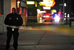 A Detroit Police officer stands guard behind barrier tape at the scene of a shooting which left three dead at a barbershop on Nov. 6, 2013. A Detroit Police officer stands guard behind barrier tape at the scene of a shooting which left three dead at a barbershop on Nov. 6, 2013.