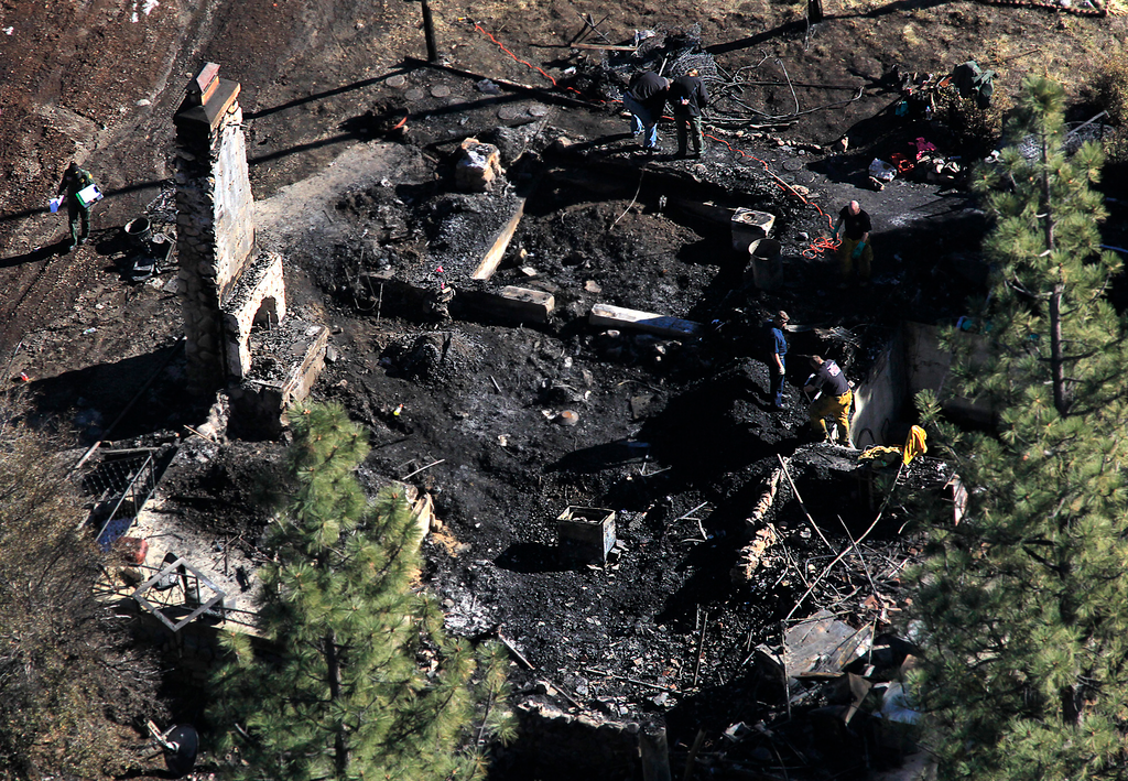 Investigators process the scene in a charred cabin in Big Bear Lake on Feb. 13, 2013, where fugitive ex-LAPD officer Christopher Dorner was holed up after trading gunfire with officers.