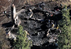 Investigators process the scene in a charred cabin in Big Bear Lake on Feb. 13, 2013, where fugitive ex-LAPD officer Christopher Dorner was holed up after trading gunfire with officers.