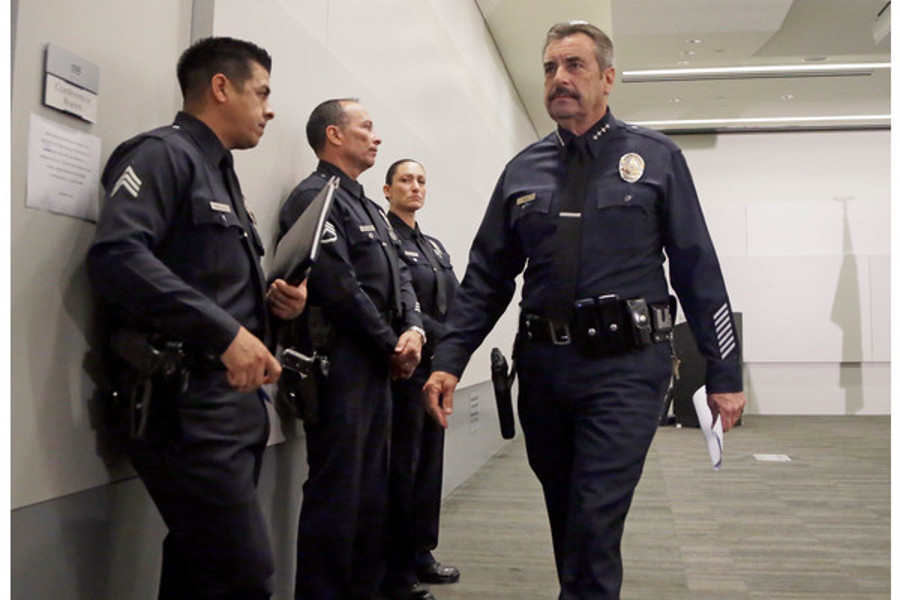Los Angeles Police Chief Charlie Beck, right, leaves a news conference at LAPD headquarters on Feb. 4.