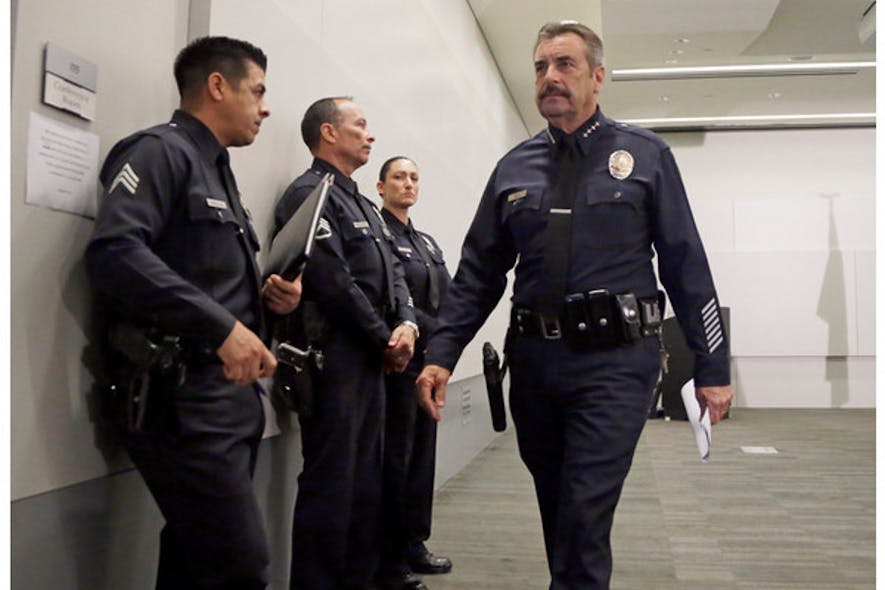 Los Angeles Police Chief Charlie Beck, right, leaves a news conference at LAPD headquarters on Feb. 4.