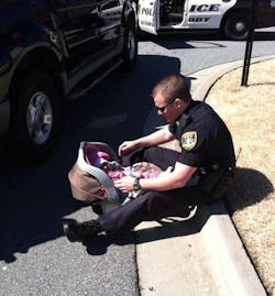 A photo of Dunwoody Officer Kerry Stallings with a baby was taken by another officer and was posted on Facebook where it went viral. A photo of Dunwoody Officer Kerry Stallings with a baby was taken by another officer and was posted on Facebook where it went viral.