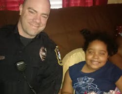 Officer Baxter Stegall is seen with 6-year-old Najah Zarif
