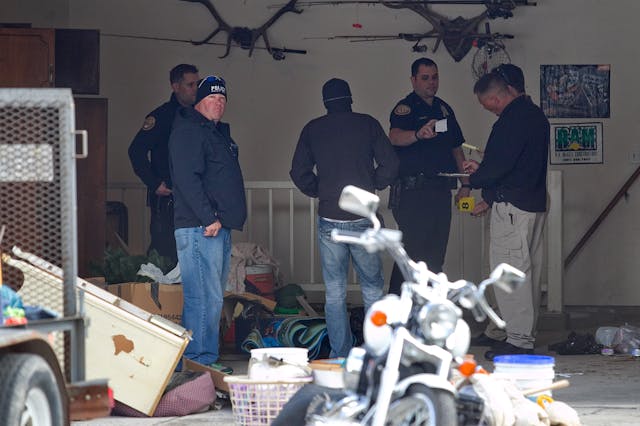 Authorities investigate a crime scene at a house in Pleasant Grove, Utah on April 13.