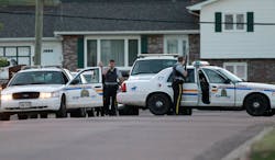 Royal Canadian Mounted Police officers take cover behind their vehicles in Moncton, New Brunswick, on June 4. Royal Canadian Mounted Police officers take cover behind their vehicles in Moncton, New Brunswick, on June 4.