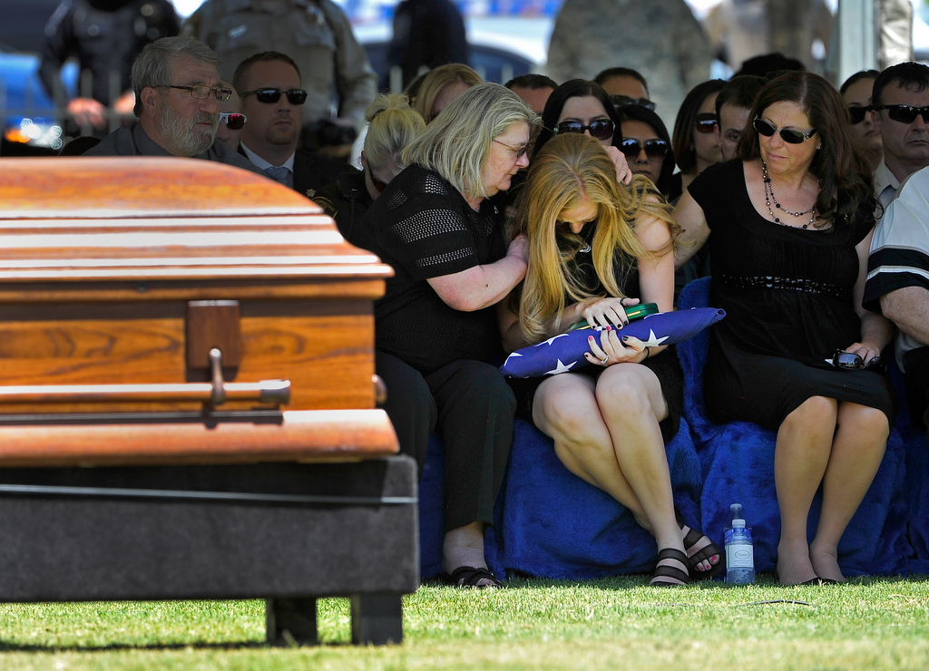 Andrea Soldo, center, is consoled by family members after receiving a flag during the funeral services for her husband and Las Vegas police officer Igor Soldo at Palm Northwest Mortuary & Cemetery on June 12.
