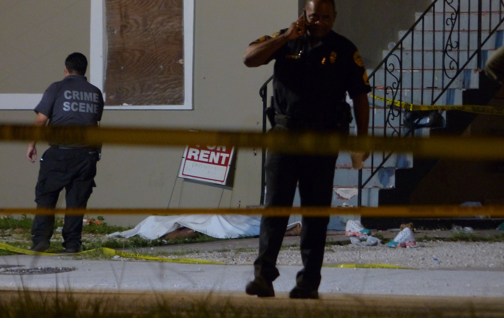 Authorities work the scene where at least two people were killed and multiple others wounded following a shooting on June 24.