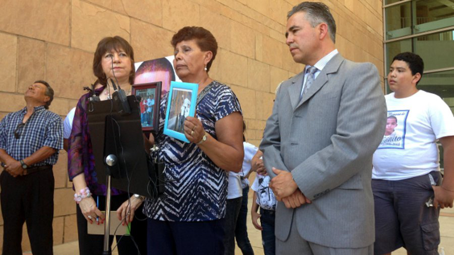 Jose Antonio Elena Rodriguez's grandmother, Taide Elena, displays pictures of her grandson at a news conference on July 29.