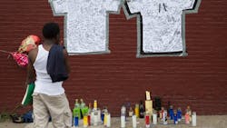 A pedestrian stands at a memorial to Lawrence Campbell, who allegedly shot and killed 23-year-old Jersey City police officer Melvin Santiago on July 14.
