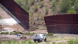 A border patrol vehicle stands guard at a section of collapsed fence just west of the Mariposa Port of Entry in Nogales, Ariz. on July 27.
