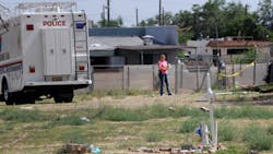Albuquerque police work at the scene where two men were found dead in a open area just north of Central Avenue at 60th Street on July 19.