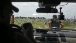 Brooks County deputies Daniel Zamarripa, left, and Domingo Aguirre check out an area outside of Falfurrias, Texas, where immigrants often hideout and seek shelter on July 17.