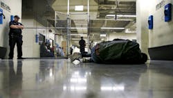 A man being booked into the Cook County Jail in Chicago sleeps on the floor of a holding pen while he awaits intake interviews. A man being booked into the Cook County Jail in Chicago sleeps on the floor of a holding pen while he awaits intake interviews.