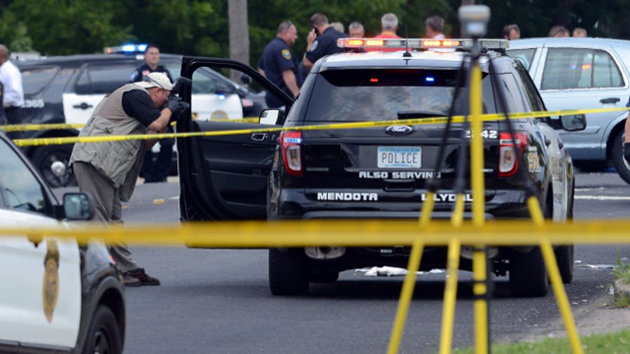 A officer with the Minnesota Bureau of Criminal Apprehension photographs an vechicle that was driven by a Mendota Heights Police officer who was shot during a traffic stop in West St. Paul on July 30.