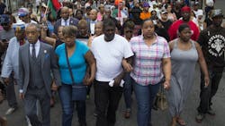 Rev. Al Sharpton, front left, and members of Eric Garners family march towards the site of his death following a service held in his name at the Mount Sinai Center for Community Enrichment on July 19.
