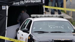 Investigators pull a sheet over the body of a suspect who allegedly shot a Jersey City Police Department officer responding to a call at a 24-hour pharmacy on July 13. Investigators pull a sheet over the body of a suspect who allegedly shot a Jersey City Police Department officer responding to a call at a 24-hour pharmacy on July 13.