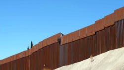 Two Mexican scofflaws climb over the border fence in Nogales, Mexico on March 12.
