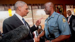 Attorney General Eric Holder talks with Capt. Ron Johnson of the Missouri State Highway Patrol at Drake&apos;s Place Restaurant on Aug. 20 in Florrissant, Mo.