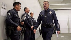 Los Angeles Police Chief Charlie Beck, right, leaves a news conference at LAPD headquarters.