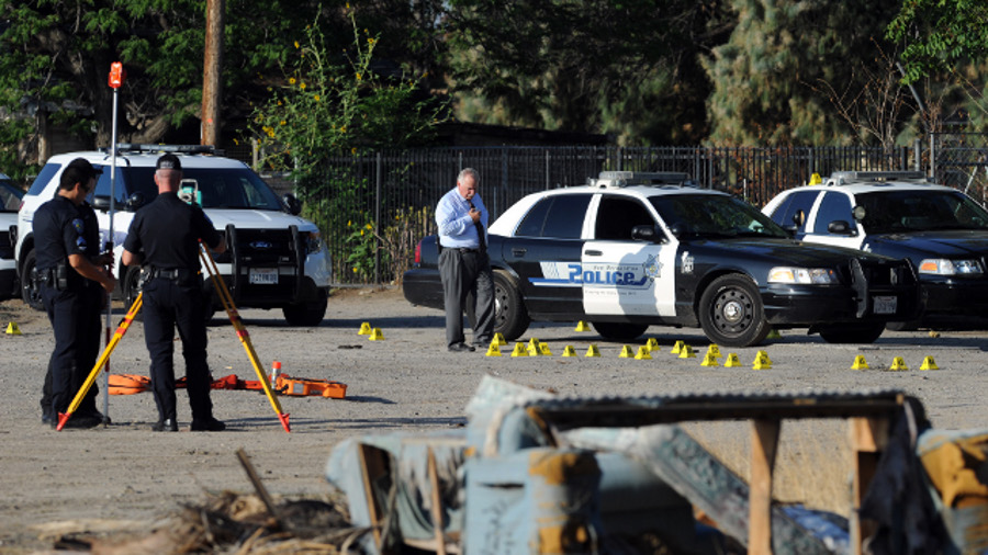 San Bernardino Police investigate the scene where a police officer shot and killed a gunman during an early morning shootout that began after another officer was gravely wounded on Aug. 22.