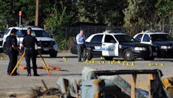 San Bernardino Police investigate the scene where a police officer shot and killed a gunman during an early morning shootout that began after another officer was gravely wounded on Aug. 22.