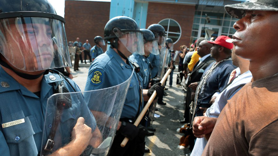 Protestor Boss Bastain of St. Louis locks arms with others as they confront Missouri State Highway Patrol troopers in front of the Ferguson police station on Aug. 11.