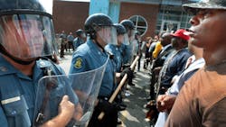 Protestor Boss Bastain of St. Louis locks arms with others as they confront Missouri State Highway Patrol troopers in front of the Ferguson police station on Aug. 11.
