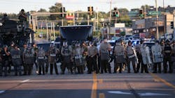 Police officers line up across W. Florissant Avenue as they watch protesters on Aug. 12 in Ferguson, Mo.