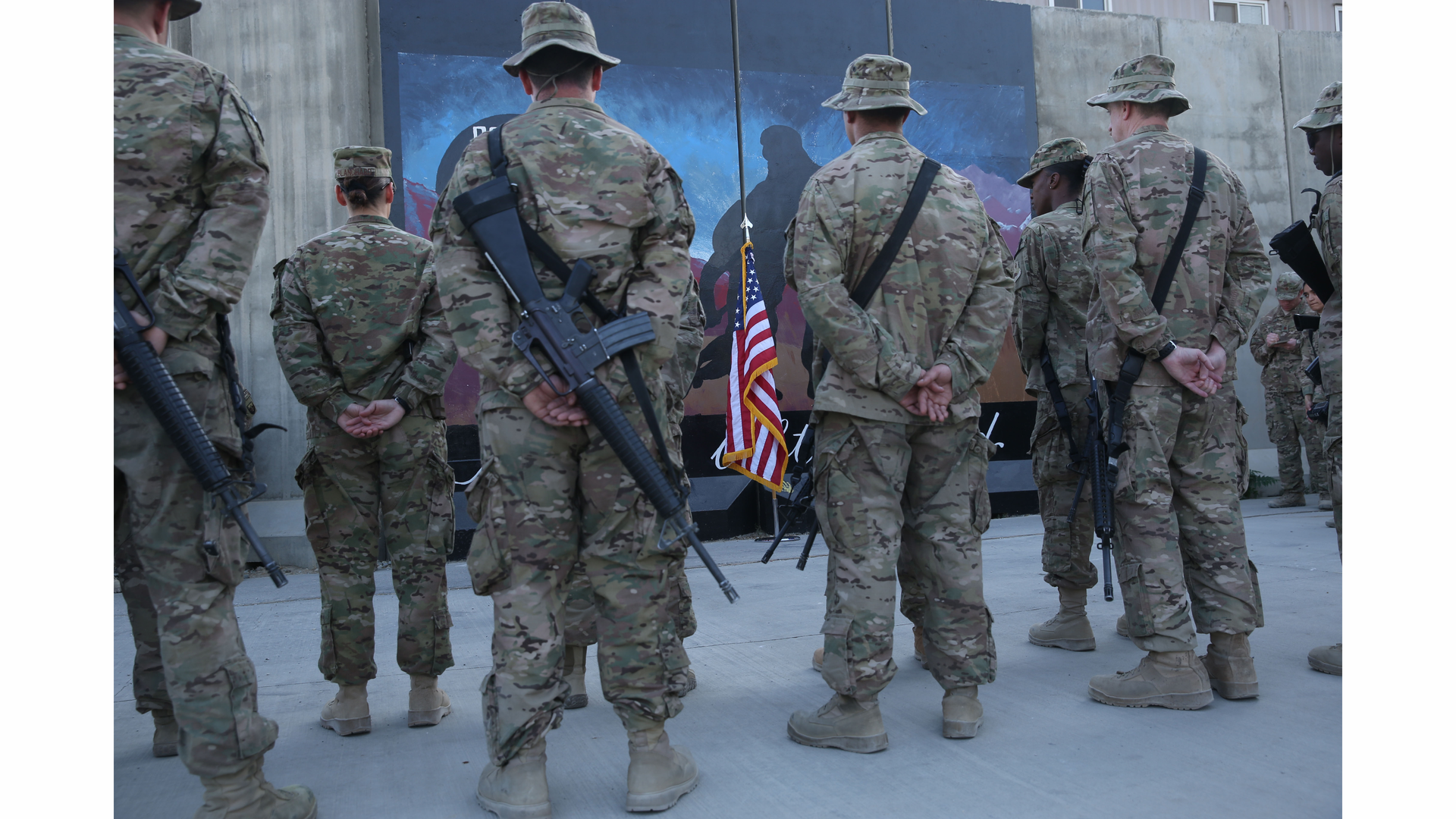 U.S. service members stand in front of a U.S. flag during a ceremony on the thirteenth anniversary of the 9/11 terrorist attacks in front of the World Trade Center Memorial at Bagram Airfield, Afghanistan on Sept. 11.