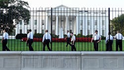 Uniformed Secret Service officers walk along the fence on the North side of the White House in Washington on Sept. 20.
