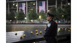 Port Authority Police Officer Donna Przybyszewski takes a moment to herself before family members are let in for the memorial observances held at the site of the World Trade Center in New York.