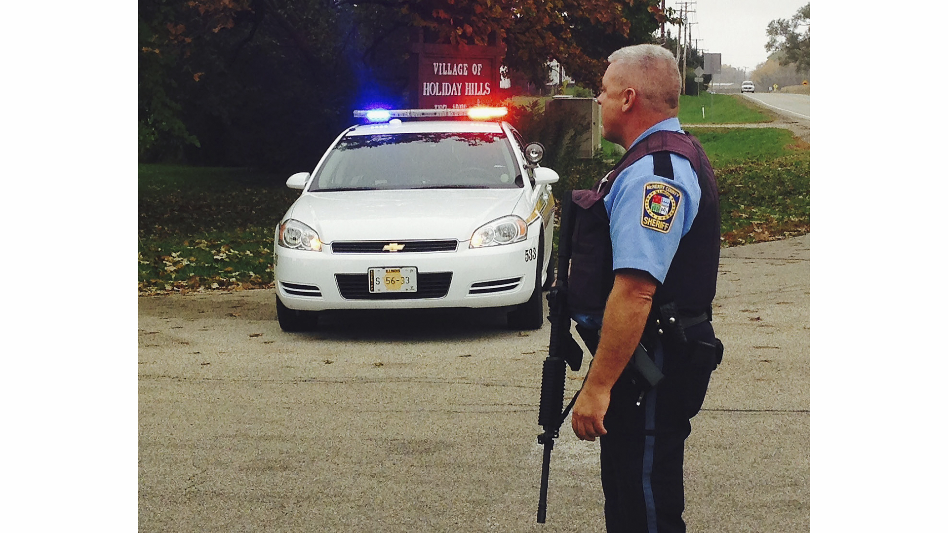 A McHenry County Sheriff's deputy blocks a street in Holiday Hills, Ill. on Oct. 16 near the site where two deputies were shot with a rifle when they responded to a domestic dispute.
