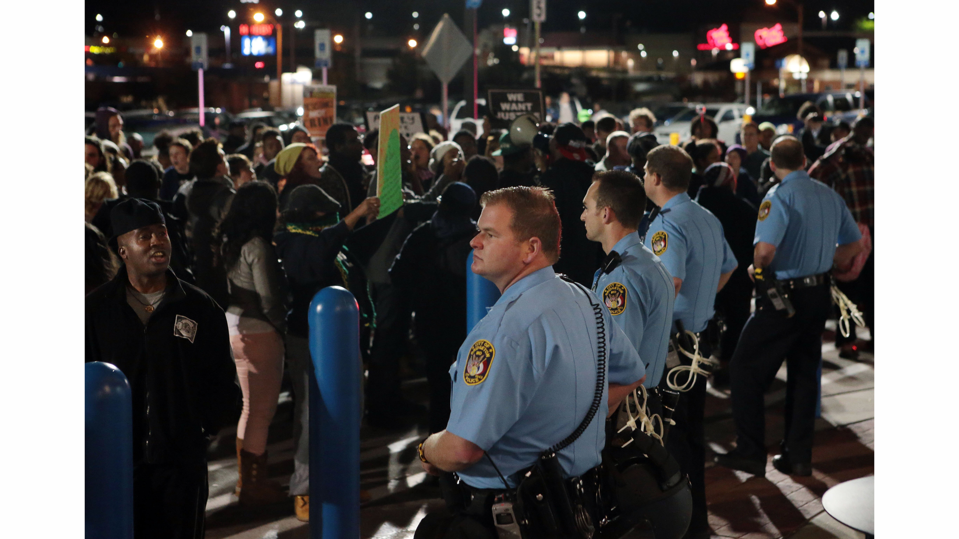 'Mr. Walmart, get on the phone with Bo McCullough to tell him to step down,' a protester says over the loud speaker shouting at a police line standing in front of the Bridgeton, Mo., Walmart Supercenter on Oct. 14.