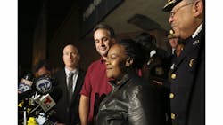 Police officials surround Keisha Gaither, second from right, mother of kidnapping victim Carlesha Freeland-Gaither, following a news conference in Philadelphia on Nov. 5.