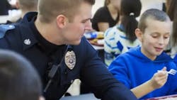 Officer Corey Sheaffer joined a boy at his school for lunch after a bet on the basketball court.