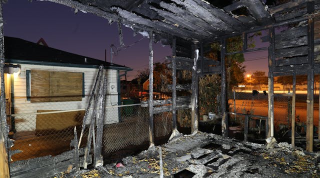 1st Place Photograph - Forensic Photography, &apos;Fire Fatality&apos;by Christopher D. Duncan, Crime Scene Investigator, Houston Police Department. This photograph was recorded during a fire investigation and the image&rsquo;s exposure settings were ISO 100, f/8, and 20 seconds. During that 20 seconds, multiple flashes were cast across the scene in order to highlight the dark structure.